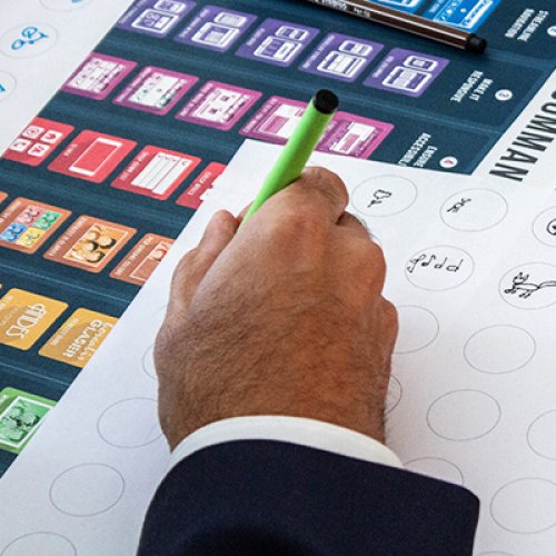 Hand mit Stift zeichnet Icons während eines Workshop