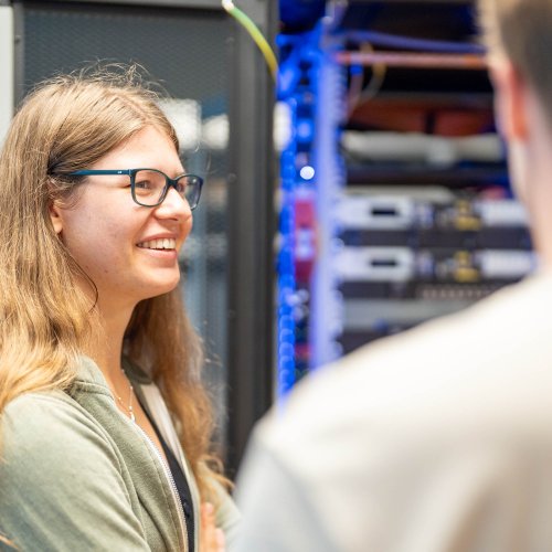 DVZ-Auszubildende steht vor einem Serverschrank
