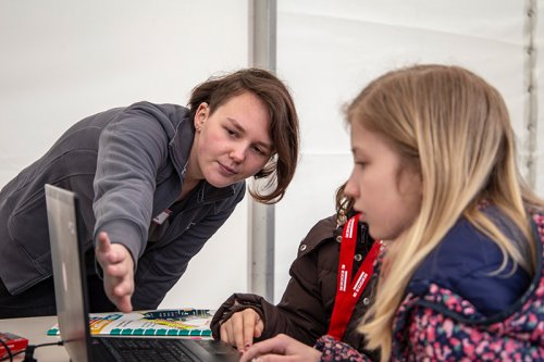 Foto: Duale Studentin Charlotte zeigt zwei Schülerinnen beim Girls'Day etwas auf dem Laptop