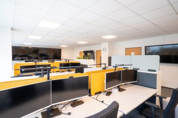 Foto von einem DVZ-Büro mit mehreren Tischen und PCs